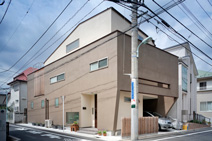 北と東で道路に接し、南側は隣の建物が間近に迫るT邸は、外に直接面する開口部を抑えた典型的な都市型住宅